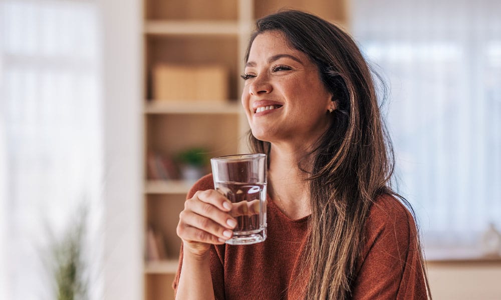 woman drinking water after her acid reflux surgery in New Jersey